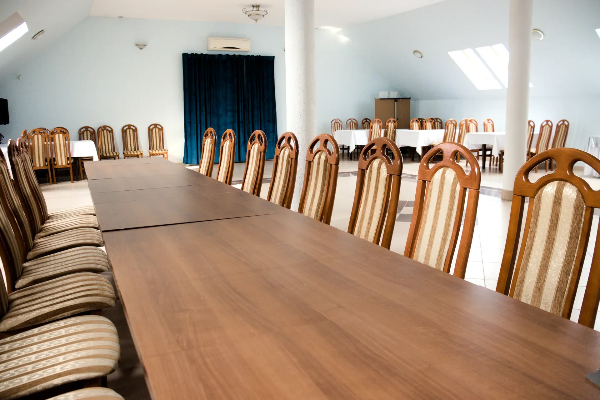 Sala konferencyjna z długimi stołami